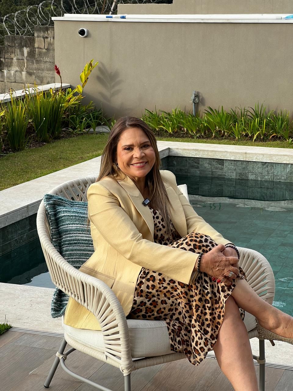 Safira Sales sentada em área externa de um imóvel